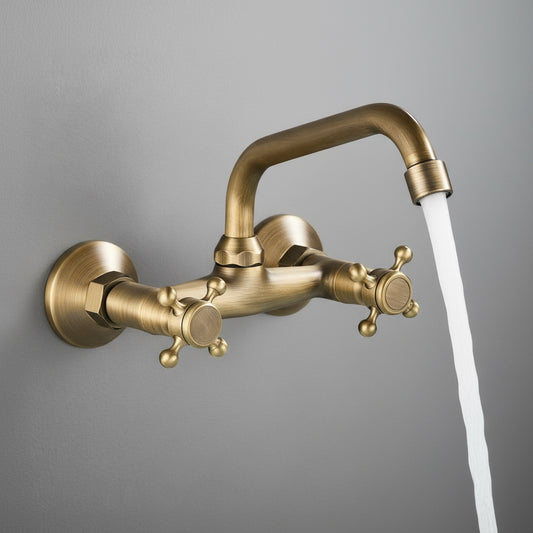 A Rozin Antique Brass Wall Mounted Bathroom Faucet with a vintage design is turned on, with water flowing into a sink or bathtub. These bathroom faucets feature two cross handles for hot and cold water, and the overall appearance gives a classic, antique feel.