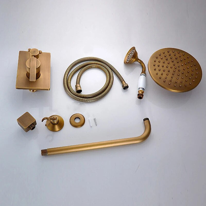 The Rozin Heritage Complete Shower System features a solid brass rainfall showerhead, handheld shower, hose, control valve, wall mounts, and connecting pipe—beautifully displayed on a light surface.