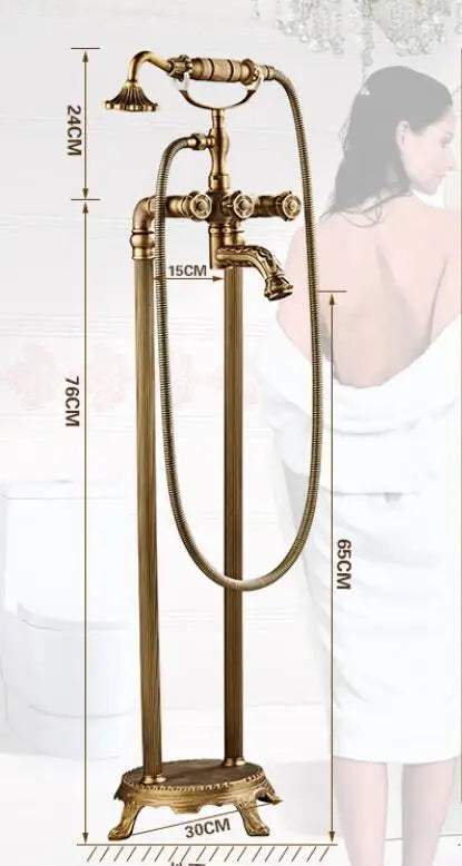 The Allfixture Antique Brass Floor Standing Bathtub Faucet Tub Filler, featuring a handheld shower attachment and dual handles, stands 76cm tall with a spout height of 65cm and base diameters of 30cm and 15cm. In the background, a woman in a bathrobe can be seen.