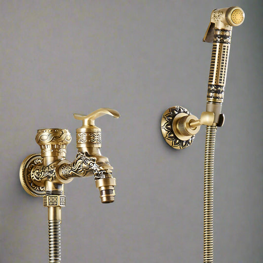 The Tiqui Wall Mounted Antique Brass Toilet Sprayer Bidet Faucet features a handheld sprayer with intricate patterns, antique bronze finish, flexible hoses, and is mounted on a gray wall.