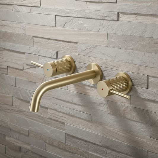 The Allfixture Windsor Brushed Gold Widespread Bathroom Faucet, wall-mounted on textured light gray stone tile, features solid brass construction, two handles, and red and blue indicators for hot and cold water.