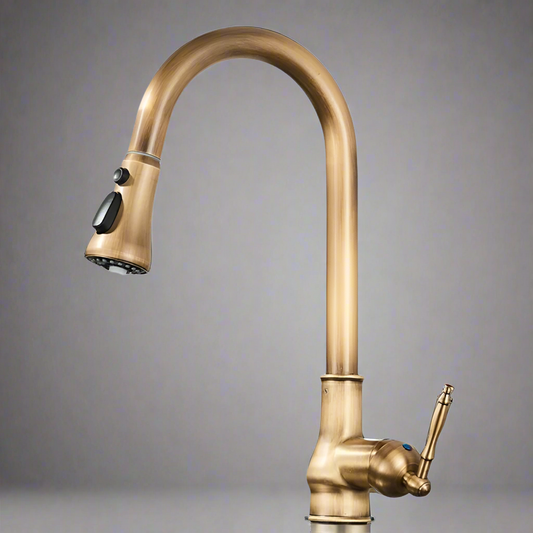 The Rozin Maison Antique Brass Pull-Down Spout Kitchen Faucet features a high, curved spout, two black buttons, and a single lever handle. This deck-mounted faucet stands out against a plain gray gradient background.