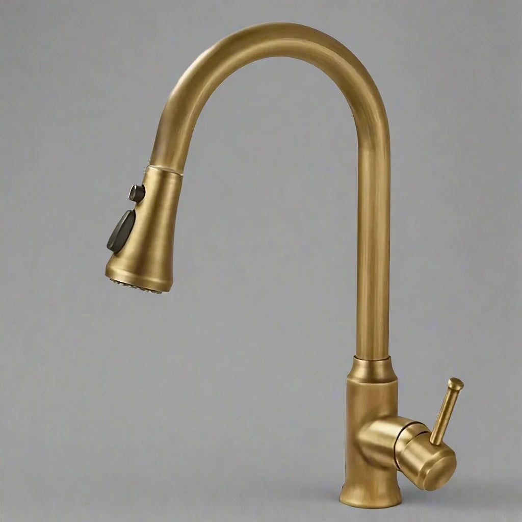 An Antique Brass Pull-Down Spout Kitchen Faucet by Rozin with a high arc and sleek, modern design pours water into a stainless-steel sink. The faucet handle is positioned to the right. In the background, reminiscent of elegant bathroom faucets, two white canisters with wooden lids are on a marble countertop.