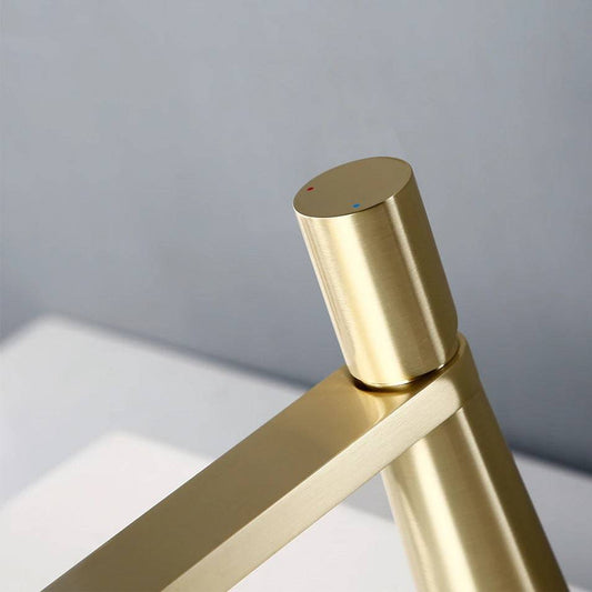 A close-up view of the contemporary Wasser™ Solid Brass Single Handle Bathroom Sink Faucet from Morsale.com, showcasing its sleek cylindrical handle. The handle has two small dots: one blue for cold water and one red for hot water. The background features a light blue wall, with a white surface underneath the faucet.