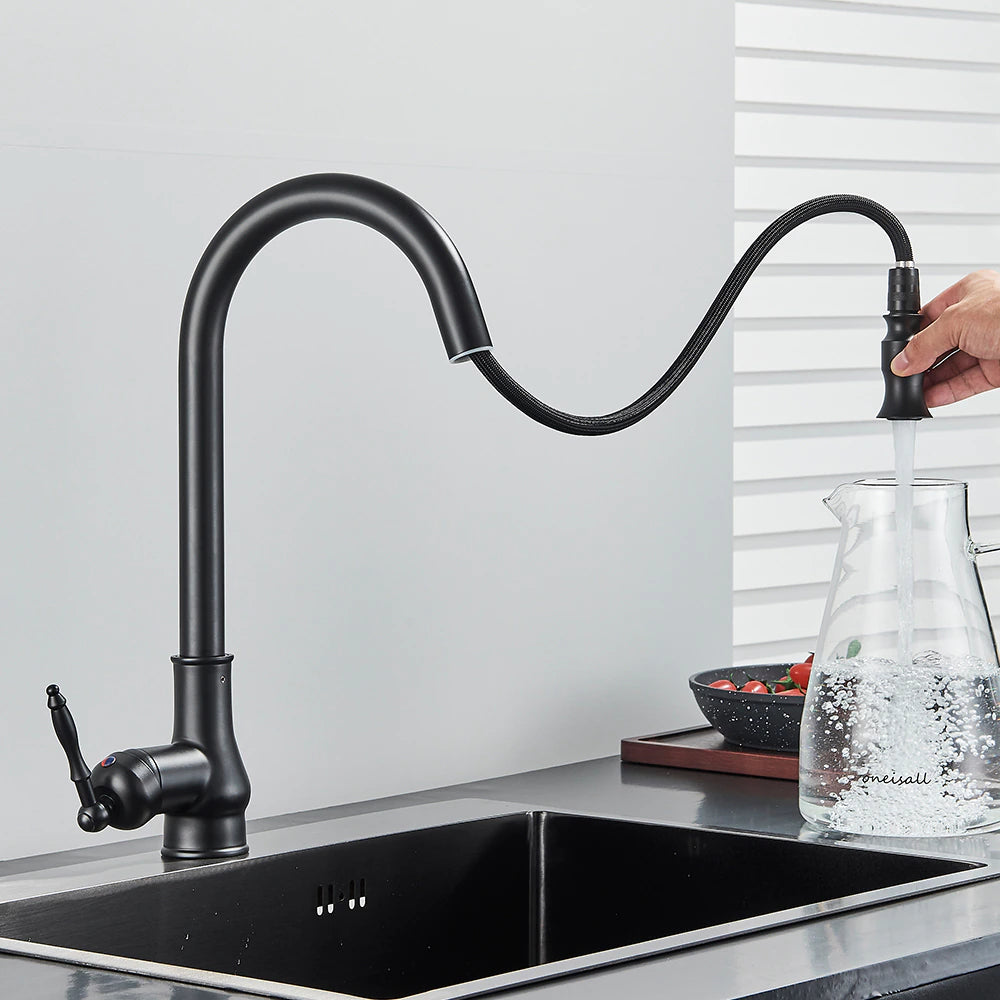 A Rozin Matte Black Pull-Down Kitchen Faucet with a high-arched spout is turned on, releasing water into a stainless steel sink set against a plain gray background.
