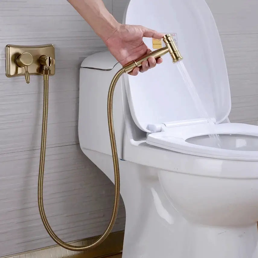 A hand holding the allfixture Wasser™ Solid Brass Hot & Cold Water Bidet Faucet with water flowing from the nozzle, reminiscent of a sleek shower head, against a dark background.