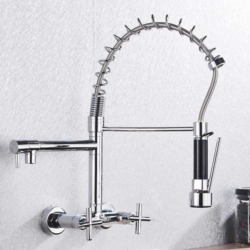 A modern Wall Mounted Dual Handle Pull Down Spout Kitchen Faucet from AllFixture, featuring a chrome finish and a flexible coil spring spout, is installed on a light-colored tiled wall. The faucet includes dual handles and an extendable pull-down sprayer with a black grip, presenting a sleek and contemporary design.