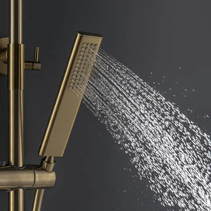 The bathroom boasts a sophisticated shower setup, showcasing the Mike Jake Solid Brass Shower Mixer with Bathtub Faucet and a handheld shower wand against a dark gray wall. Water cascades from the brass rain shower head, creating droplets that glisten in the light. A sleek sink faucet adds to the modern aesthetic, while light gray cabinets provide an elegant backdrop.