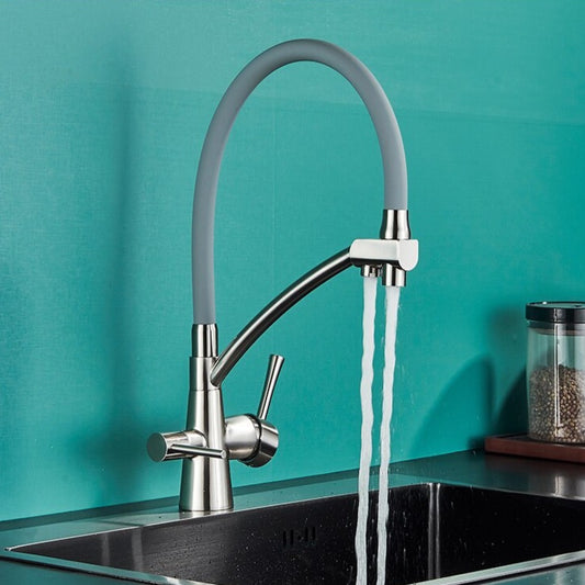 The Rozin Windsor Kitchen Faucet With Purified Water Tap features a curved, flexible gray spout that releases two water streams into a stainless steel sink, set against a teal wall with coffee beans nearby.