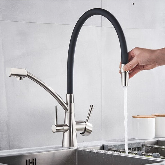 The Rozin Deck Mounted Kitchen Faucet with Purified Water Tap showcases a sleek brushed nickel finish and a high-arc, flexible black hose. Water flows gracefully from the spout into a stainless steel sink, set against a backdrop of light gray tiles and accompanied by a small, partially visible container.