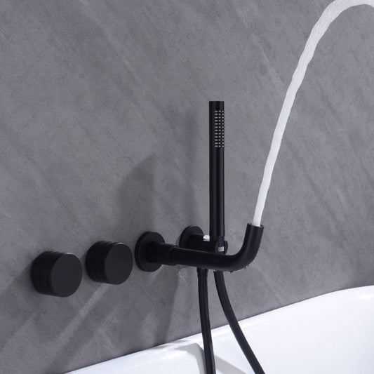 A modern AllFixture Bathroom Shower Faucet Set Mixer Valve with Bathtub Filler, featuring a black matte finish, is mounted on a grey tiled wall. The setup includes two round knobs and a sleek hand-held showerhead, which is spraying water. The system, combining both the shower and bathroom sink faucets, is positioned above a white bathtub.