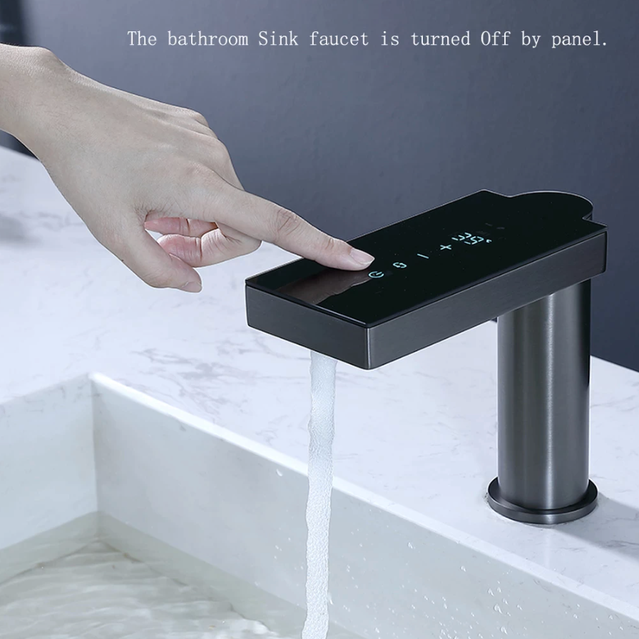 A Sensor Operated Temperature Display Faucet by Bagnolux, with a modern black electronic finish and a sleek rectangular design, is mounted on a white marble countertop. Water flows steadily from the spout into the sink below. This innovative bathroom faucet features touch controls and a display screen on its top surface, combining elegance with cutting-edge technology.