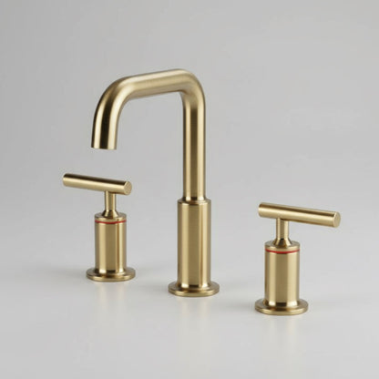 The Tiqui Windsor Widespread Brass Faucet features a modern gold finish, curved spout, two T-shaped handles, and a durable ceramic cartridge—all showcased on a plain light gray background.