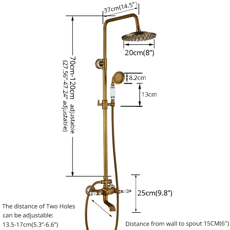 A wall-mounted Rozin Antique Brass Complete Shower Faucet Set with dual handles and white ceramic accents, labeled 'H' for hot and 'C' for cold. Water flows from the spout into a sink below, with flexible metal hoses connected to the faucet. The background is a gray tiled wall.