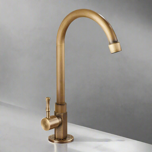 The ZGRK Single Handle Antique Brass Kitchen Faucet, featuring a high curved spout and single lever handle, is installed on a marble countertop against a neutral gray background.