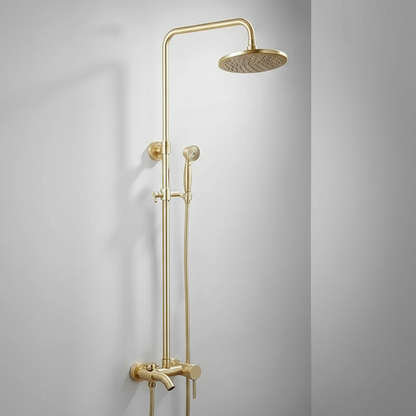 The Tiqui Maison Exposed Pipe Shower System features a modern gold finish, round overhead showerhead, handheld attachment, and sleek fixtures, all mounted on a white bathroom wall.