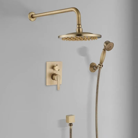 Mounted on a light gray wall, the Antique Brass Shower System with Handheld Shower from Morsale.com showcases a large overhead rain shower head, a flexible handheld showerhead, a control lever, and a secondary knob. Its minimalist design exudes modern elegance similar to high-end kitchen sink faucets.