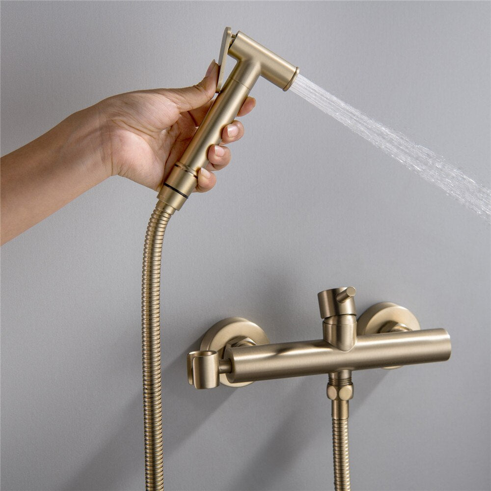 The Wasser™ Wall Mounted Toilet Sprayer Bidet Faucet by allfixture showcases a sleek, brass design. It includes a handheld sprayer on the left connected by a flexible hose, a central control knob, and an additional outlet on the right side, embodying the elegance of premium bathroom fixtures. The backdrop is light grey.