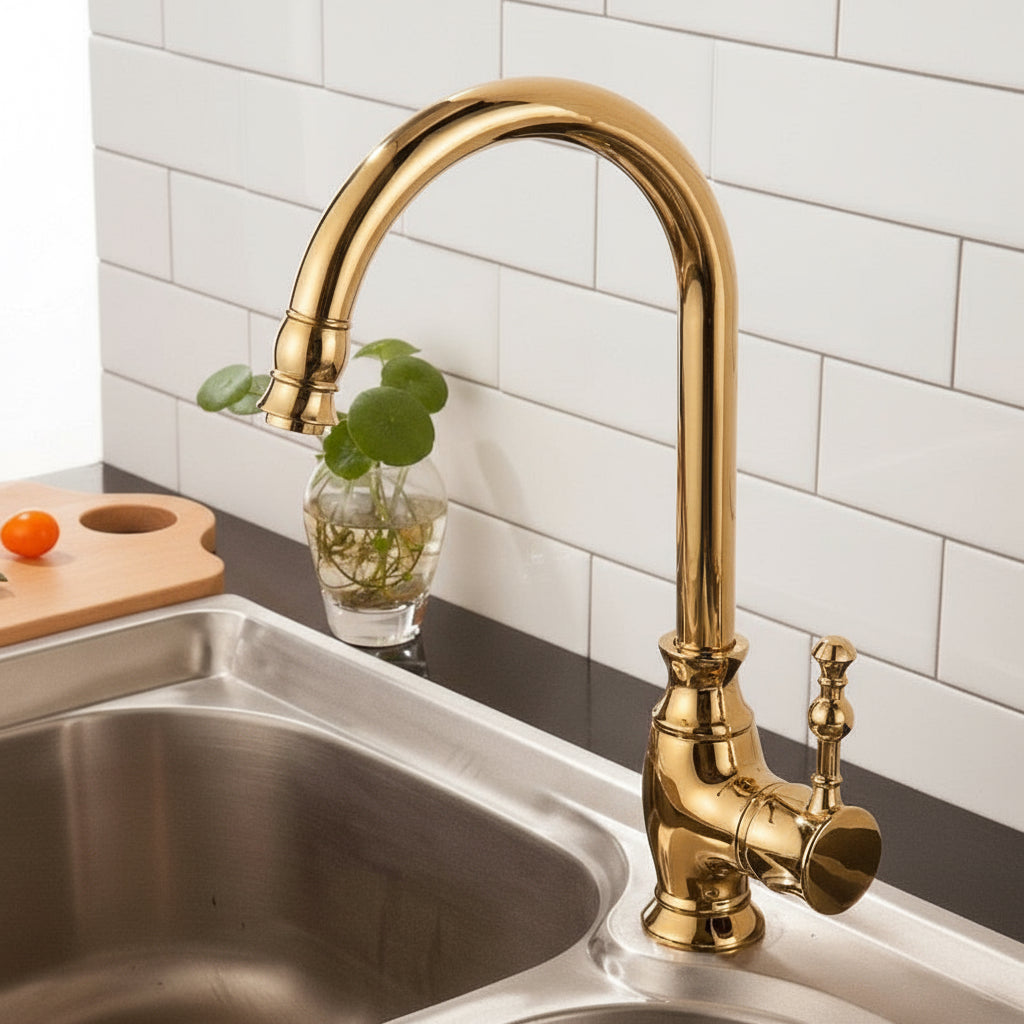 The AllFixture Maison Polished Gold Kitchen Faucet with a curved spout and pull-down spray head is installed on a stainless steel sink. In the background are white subway tiles and a small glass vase holding a plant.