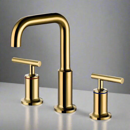The Tiqui Double Handle Deck Mounted Bathroom Faucet features a gold-colored, solid brass curved spout with red and blue ringed handles, set on a white countertop against a gray background.