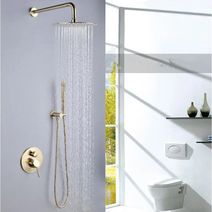 A modern bathroom features the Wasser™ Brushed Gold Shower Set With Handheld Shower from Morsale.com, elegantly mounted on a gray wall. Nearby, a white towel hangs on a hook, and a white toilet sits against the back wall. The floor is adorned with a gray rug, and close to the bathroom sink faucet, a small stack of books rests beside the toilet.