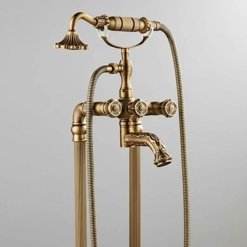 The AllFixture Heritage Floor-Mounted Bathtub Filler & Hand Shower Faucet features dual handles, a handheld showerhead on a flexible hose, decorative knobs, ribbed pipes, and an antique brass finish set against a plain light background.
