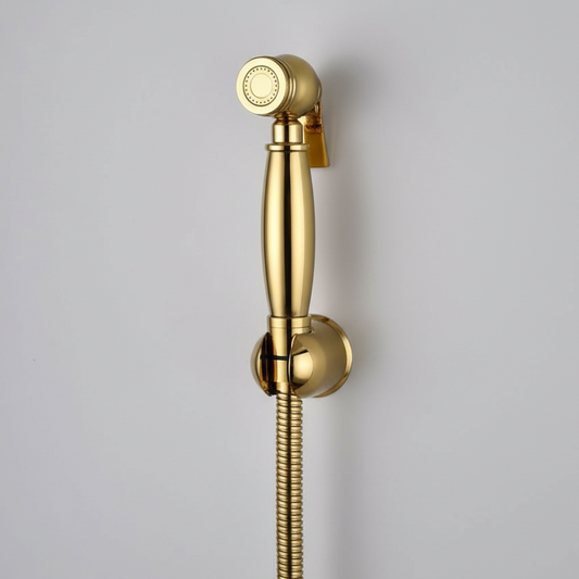 The AllFixture Windsor Wall Mounted Bidet Sprayer in gold, with a matching mount and flexible hose, is attached to a light gray wall—ideal for enhancing your bathroom hygiene.