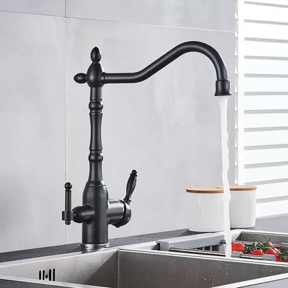 A Uythner Contemporary Kitchen Faucet With Filtered Water Tap is mounted over a stainless steel sink. The faucet is turned on, with water flowing from the spout. Behind the sink are a white container and a variety of fresh vegetables, including tomatoes.