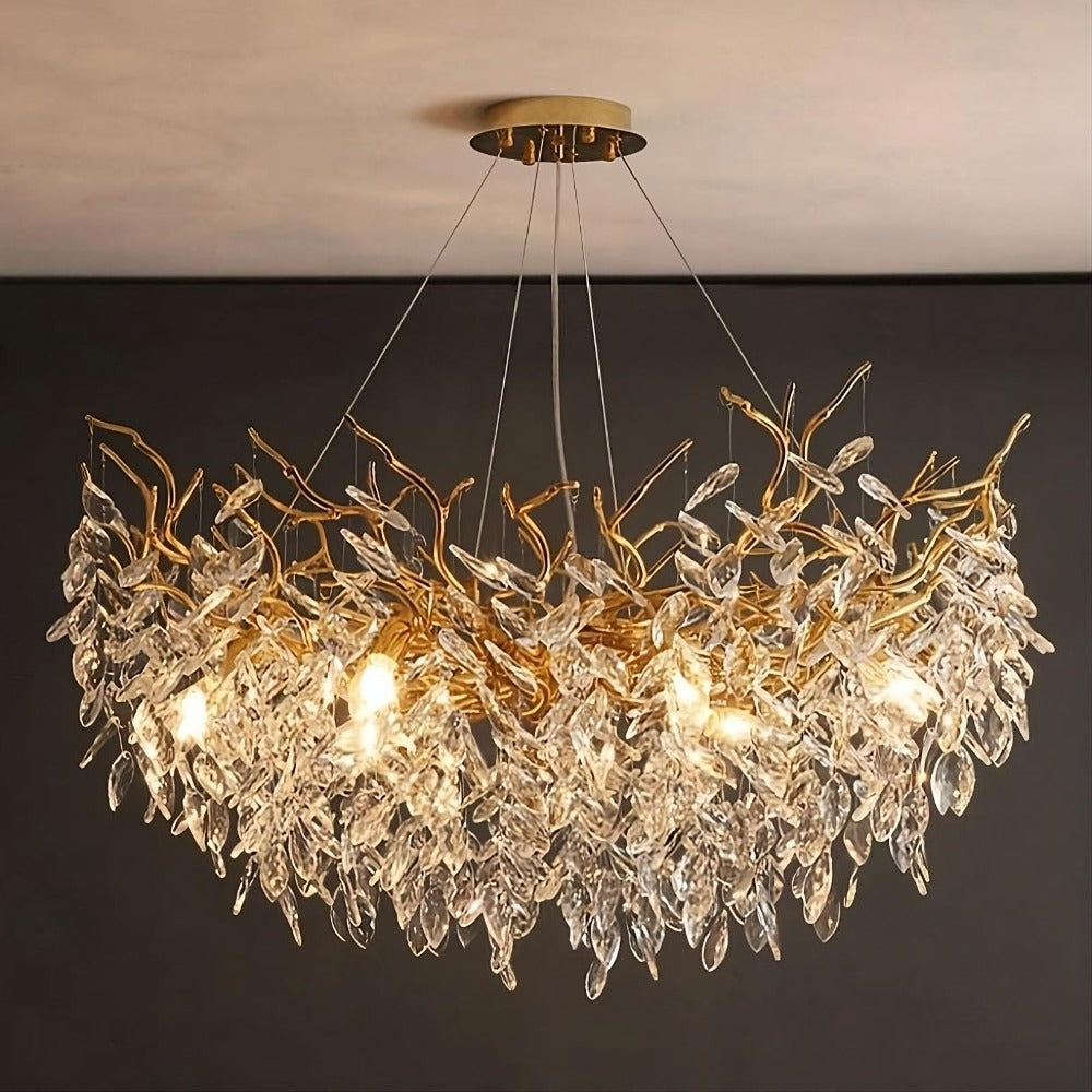 The Albero Collection Crystal Ceiling Light Fixture from Morsale.com is a modern chandelier that hangs elegantly from the ceiling, featuring a design reminiscent of intertwined golden branches adorned with numerous crystal-like leaves. With an adjustable hanging wire and dimmable LED bulbs, this chandelier emits a warm glow that illuminates the intricately detailed leaves, creating a luxurious atmosphere.