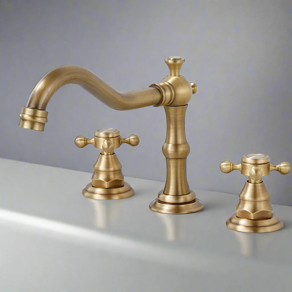 The Allfixture Antique Brass Gold Bathroom Faucet, with dual cross handles for hot and cold water, is installed on a white countertop against a plain gray background.