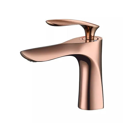 A close-up view of the Allfixture Rose Gold Bathroom Faucet – Deck Mounted Basin Sink Mixer showcases water gracefully flowing into a pristine white sink. The background features a gray textured wall. This faucet boasts a contemporary design with smooth curves and a polished finish, epitomizing modern bathroom designs.