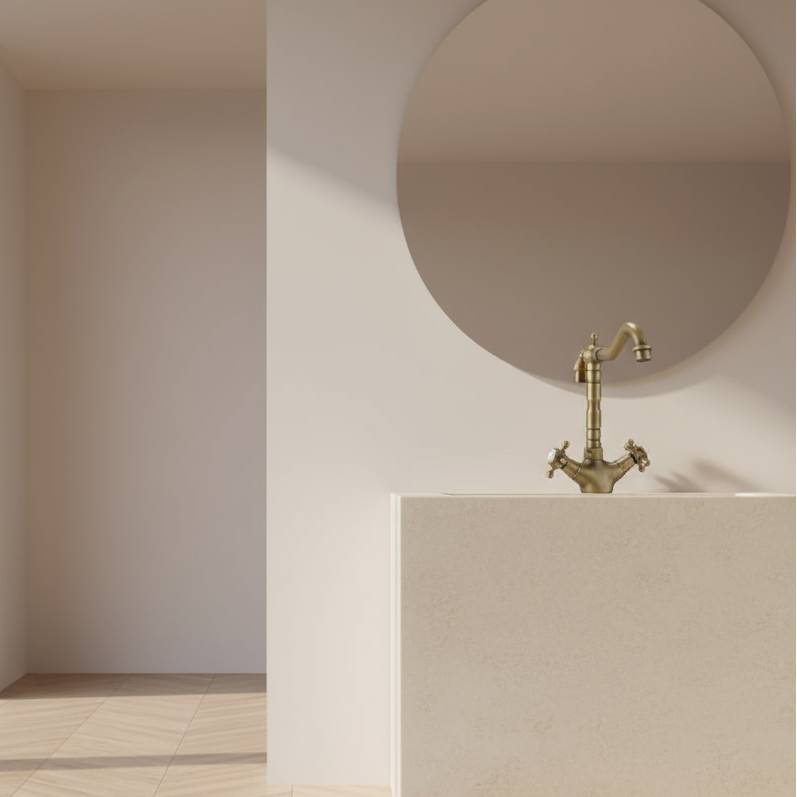 A minimalist bathroom features Allfixture’s Heritage Two Handle Bathroom Sink Faucet, paired with a beige sink and round mirror, all set against light walls and bright natural light.