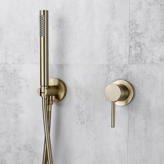 A sleek, modern shower setup features the Wasser™ Wall Mounted Handheld Showerhead in brushed brass from Morsale.com, complete with a flexible hose mounted on a light gray tiled wall. To the right is a matching round brass shower control handle. The design is minimalist and contemporary, perfectly complementing the elegant bathroom sink faucet nearby.