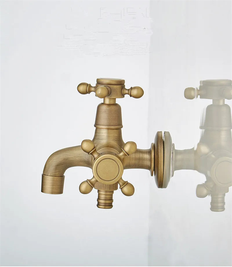 The Allfixture Antique Brass Wall Mounted Bidet Faucet Hand Shower combines vintage aesthetics with practical functionality. Crafted from durable brass material and finished with a brushed texture, this elegant faucet features a single spout alongside dual cross handles for hot and cold water control. A reflection on the adjacent glass surface enhances the symmetry and overall visual appeal.