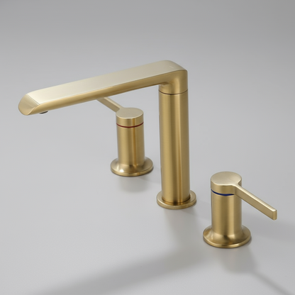 The Windsor Widespread Bathroom Sink Faucet by Morsale.com features a modern brushed gold finish and dual handles—one red-lined, one blue—set against a light gray surface, offering both style and functionality for your bathroom.