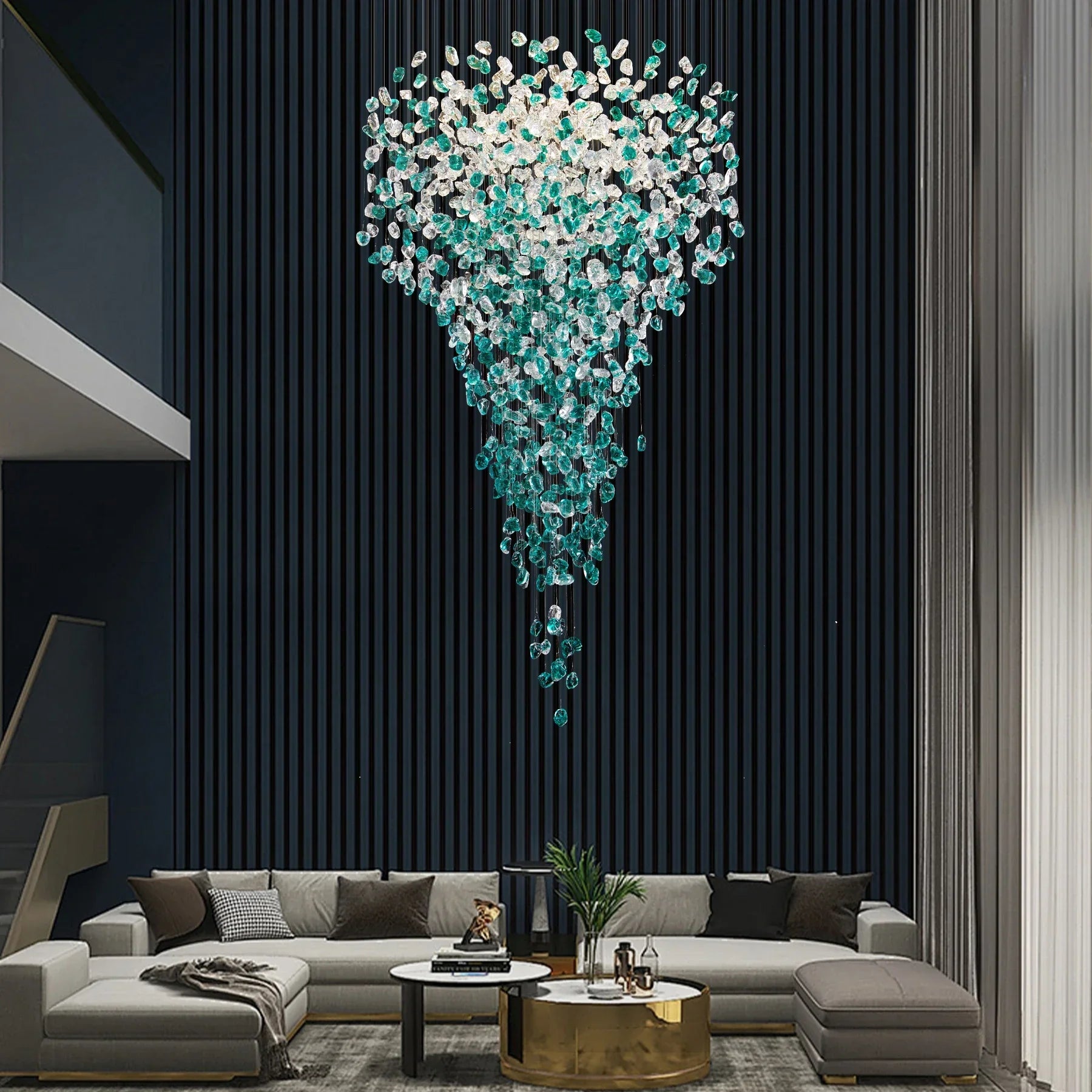 A modern living room features a gray sectional sofa and a gold coffee table. The Morsale Crystal Pendant Foyer Chandelier with LED bulbs creates a striking Art Deco focal point against a black textured wall, while tall windows on the right flood the space with natural light.