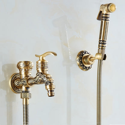 A decorative Wall Mounted Antique Bronze Toilet Sprayer Bidet Faucet from Tiqui set against a light background. The set includes an intricately designed faucet handle, a water spout with ornate detailing, and an adjustable handheld sprayer attached to a flexible hose. The design features floral and geometric patterns.