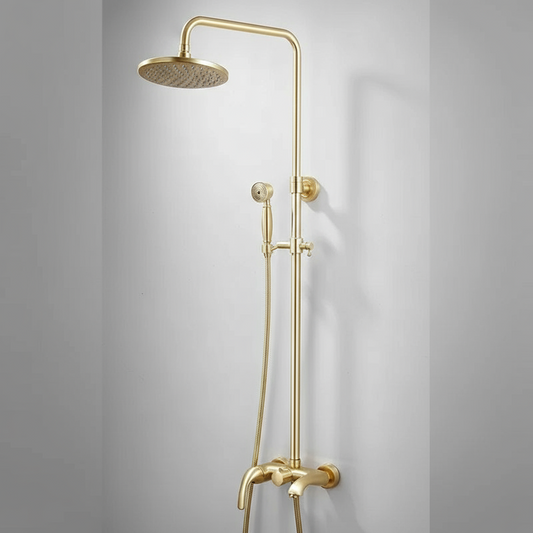 The Tiqui Maison Exposed Pipe Shower System is a modern gold-colored solid brass set, mounted on a white wall, with a large round overhead showerhead, handheld shower, and a sleek minimalist design.