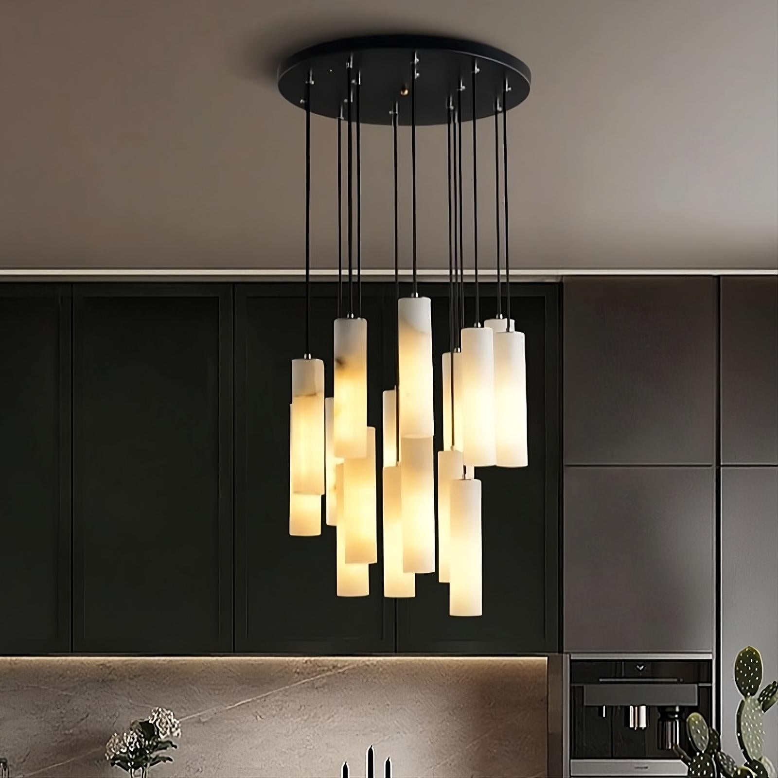 Modern black ceiling light fixture featuring the Moonshade™ Marble Pendant Lighting Fixture from Morsale.com, arranged at varying heights. The background includes dark green cabinetry and a beige countertop with a built-in oven and subtle decor elements. The natural imported marble adds an elegant touch to the contemporary space.