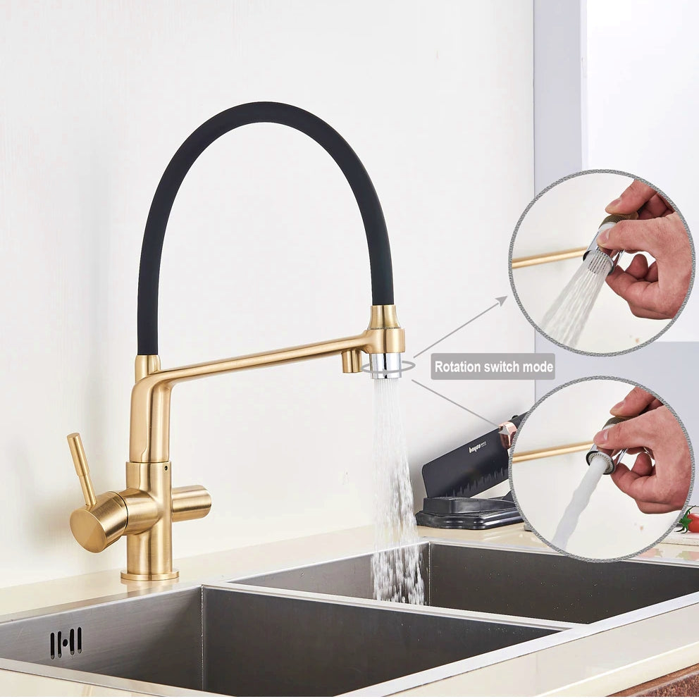 An allfixture Brushed Gold Solid Brass Kitchen Faucet With Purified Water Tap, featuring a sleek gold finish and a flexible black hose, is installed over a stainless steel sink. The faucet has a single lever handle and a high-arching spout, providing it with a contemporary and stylish design.