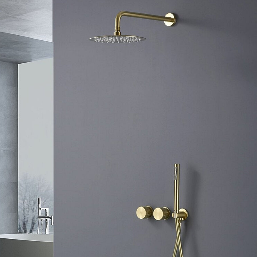 A minimalist bathroom features a matte gray wall with the modern Aodei Wasser™ Complete Shower System in brushed gold. The wall-mounted rain showerhead, sleek hand shower, and dual control knobs complement the simple yet elegant design. A partial view of a washbasin with a matching bathroom sink faucet is seen in the background.