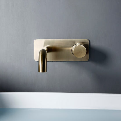 An elegant Wasser™ Wall Mounted Brass Bathroom Faucet by AllFixture is installed on a gray wall, gracefully pouring water into a pristine white sink below. The water runs smoothly, forming tiny bubbles in the sink, reminiscent of the gentle flow from a luxury shower faucet.