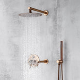 A modern shower setup featuring the Wasser™ Complete Shower System with Bathtub Filler in Rose Gold by Morsale.com, including a round, overhead rain showerhead and a separate handheld showerhead, mounted on a light gray textured wall. Water pours from the overhead showerhead creating a luxurious cascade effect akin to high-end bathroom faucets.