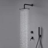 A Complete Shower System With Handheld Sprayer in Matte Black from Morsale.com is mounted on a grey wall, releasing a stream of water. Below the showerhead are two black wall-mounted control knobs and a handheld shower attachment.