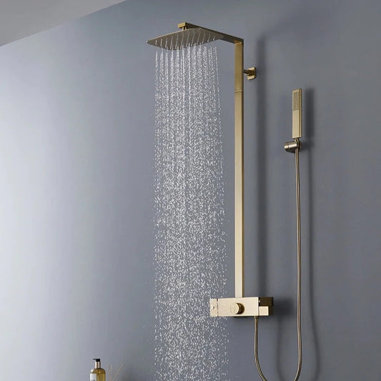 The Mike Jake Solid Brass Shower Set With Bathtub Faucet features a modern bathroom setup with a square rainfall showerhead mounted on the wall, releasing water. Completing the sleek look of the shower faucet, the set includes a handheld showerhead attached to a hose and wall bracket. The wall behind is painted in a soft gray color.