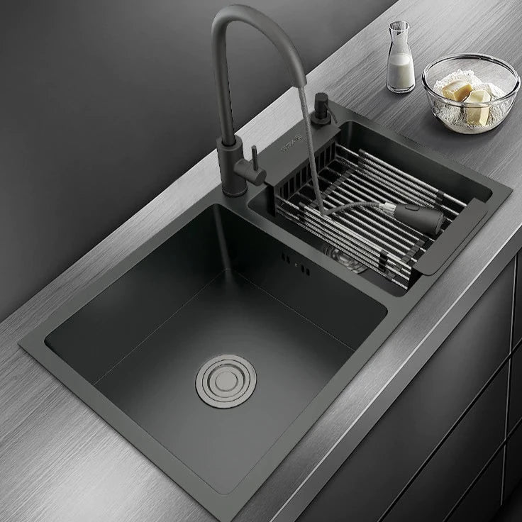 A modern AllFixture 304 Stainless Steel Double Bowl Kitchen Sink with a matte black finish is installed on a countertop. The kitchen faucet features a deep basin with a circular drain, a black handle, and an adjacent drying rack with a dish and soap dispenser. A small bowl of butter is on the counter.