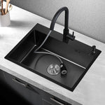The AllFixture 304 Stainless Steel Single Bowl Kitchen Sink With Faucet features a matte black finish, pull-out faucet, and soap dispenser, set in a white countertop with dark cabinetry. Cooking utensils sit in a holder nearby.