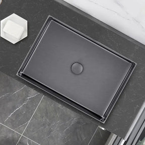 A modern rectangular sink, the Mike Jake SUS304 Stainless Steel Rectangle Bathroom Sink in Gunmetal, sits on a marble countertop. The sink, with its matte black finish and centered drain cover, is complemented by a sleek kitchen sink faucet. To the left of the sink is a black soap dispenser. The countertop features clean, white marble with subtle gray veining.