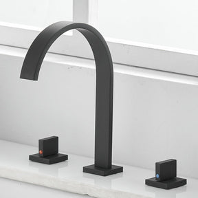 A minimalist black sink faucet from AllFixture, featuring an arching design, is mounted on a white countertop. The Double Handle Deck Mounted Faucet includes two lever handles—one on each side—with subtle red and blue indicators for hot and cold water respectively. In the background, a white window sill completes the scene.