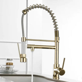 Hand holding the spray head of an allfixture Solid Brass Pull Out Spring Spout Kitchen Faucet with a matte black finish and flexible, coiled spring design, over a sink filled with strawberries. The faucet is turned on, and water is flowing from the spray head. Nearby, there is a wine glass and a cutting board with eggplants.